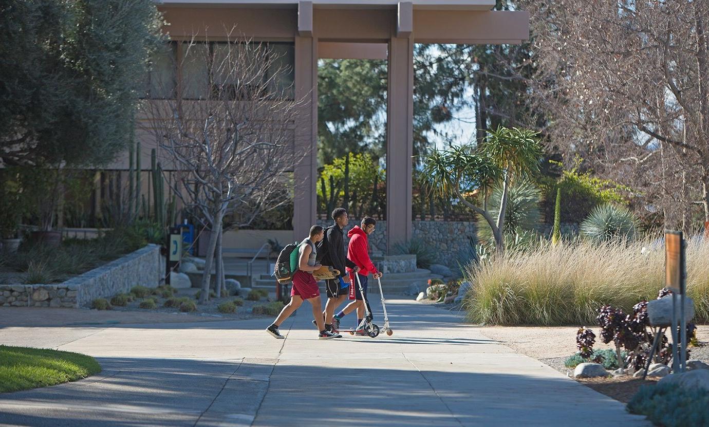 three students walk in front of McConnell towards holden garden